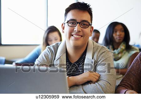 Stock Photo - Male University Student Using Laptop In Classroom. Fotosearch