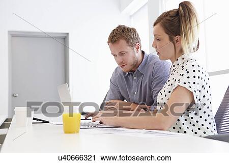 Stock Image - Man And Woman Working Together In Design Studio. Fotosearch