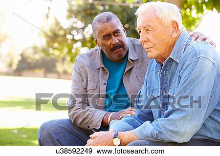 Stock Photo - Man Comforting Unhappy Senior Friend Outdoors. Fotosearch