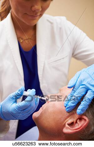 Stock Image - Man Having Botox Treatment At Beauty Clinic. Fotosearch