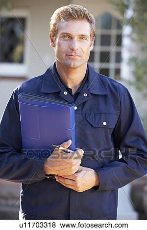 Stock Photo - Man in overalls holding folder. Fotosearch