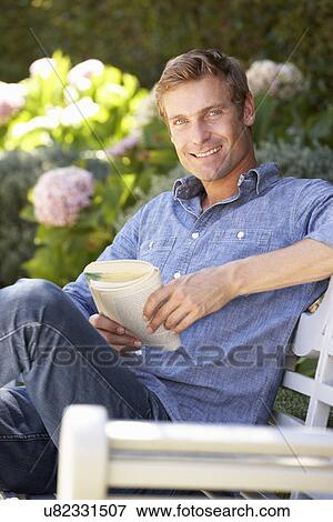 Stock Photo - Man reading in garden. Fotosearch