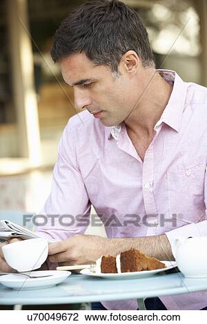 Man reading paper outside café View Large Photo Image Stock Image - Man reading paper outside café. Fotosearch