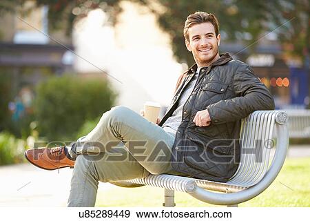 Stock Photo - Man Relaxing On Park Bench With Takeaway Coffee. Fotosearch