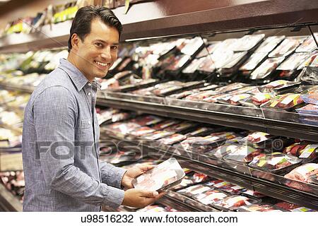 Stock Image - Man shopping in supermarket. Fotosearch