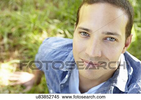 Man sitting on grass View Large Photo Image Stock Photography - Man sitting on grass. Fotosearch