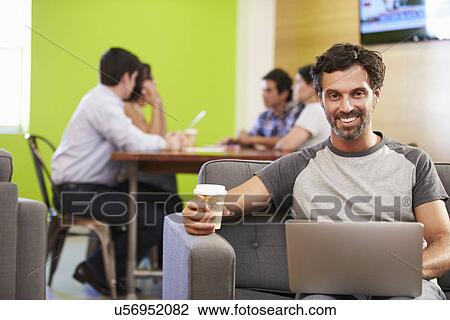 Man Sitting On Sofa And Working In Design Studio View Large Photo Image Stock Image - Man Sitting On Sofa And Working In Design Studio . Fotosearch