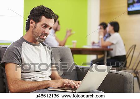 Man Sitting On Sofa And Working In Design Studio View Large Photo Image Stock Photograph - Man Sitting On Sofa And Working In Design Studio . Fotosearch
