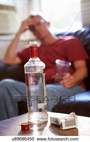 Man Sitting On Sofa With Bottle Of Vodka And Cigarettes View Large Photo Image Stock Image - Man Sitting On Sofa With Bottle Of Vodka And Cigarettes. Fotosearch