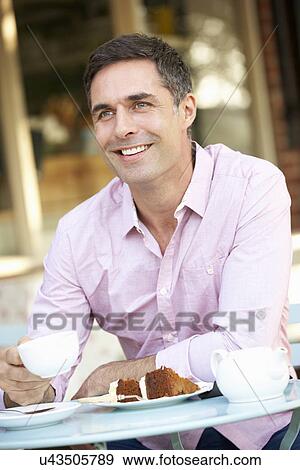 Stock Photo - Man sitting outside café. Fotosearch