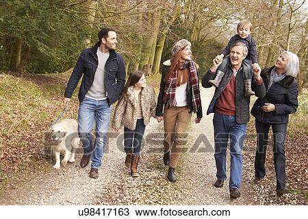Stock Image - Man Taking Dog For Walk On City Street. Fotosearch