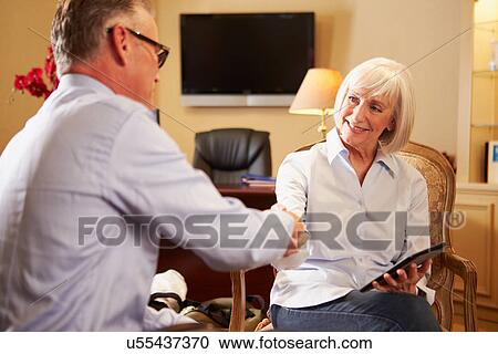 Stock Image - Man Talking To Female Counsellor Using Digital Tablet. Fotosearch