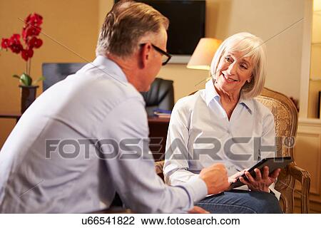Stock Image - Man Talking To Female Counsellor Using Digital Tablet. Fotosearch