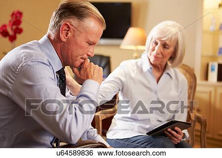 Stock Photograph - Man Talking To Female Counsellor Using Digital Tablet. Fotosearch