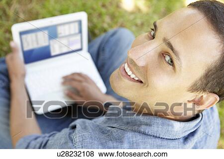 Man using laptop outdoors View Large Photo Image Stock Photo - Man using laptop outdoors. Fotosearch