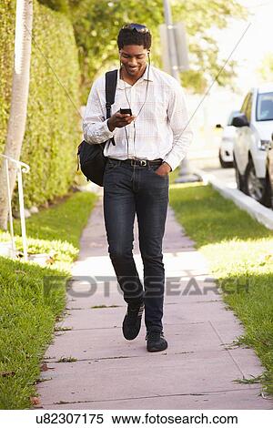 Man Walking Along Street To Work Listening To Music View Large Photo Image Stock Photography - Man Walking Along Street To Work Listening To Music. Fotosearch