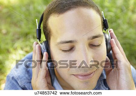Man wearing headphones outdoors View Large Photo Image Stock Image - Man wearing headphones outdoors. Fotosearch