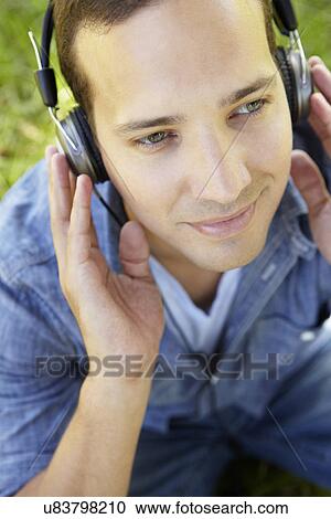 Man wearing headphones outdoors View Large Photo Image Stock Image - Man wearing headphones outdoors. Fotosearch