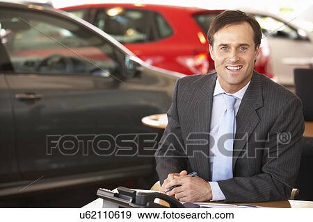 Man working in car showroom View Large Photo Image Stock Photo - Man working in car showroom. Fotosearch