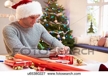 Man Wrapping Christmas Gifts At Home View Large Photo Image Stock Photo - Man Wrapping Christmas Gifts At Home. Fotosearch