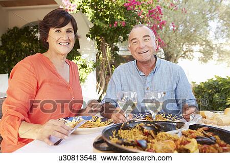 Mature Hispanic Couple Enjoying Outdoor Meal At Home View Large Photo Image Stock Photo - Mature Hispanic Couple Enjoying Outdoor Meal At Home . Fotosearch