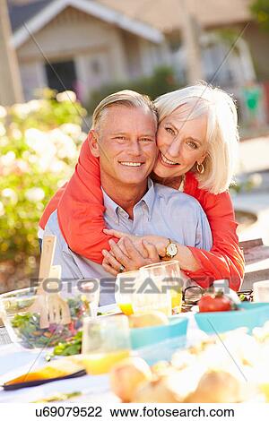 Mature Romantic Couple Enjoying Outdoor Meal In Garden View Large Photo Image Stock Image - Mature Romantic Couple Enjoying Outdoor Meal In Garden. Fotosearch