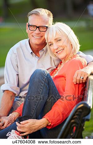 Mature Romantic Couple Sitting On Park Bench Together View Large Photo Image Stock Photo - Mature Romantic Couple Sitting On Park Bench Together. Fotosearch