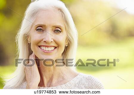 Stock Image - Mature Woman Relaxing In Autumn Landscape. Fotosearch