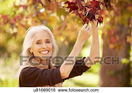 Stock Photograph - Mature Woman Relaxing In Autumn Landscape. Fotosearch