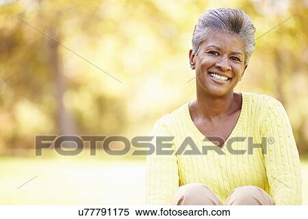 Stock Photography - Mature Woman Relaxing In Autumn Landscape. Fotosearch