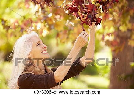 Mature Woman Relaxing In Autumn Landscape View Large Photo Image Stock Photography - Mature Woman Relaxing In Autumn Landscape. Fotosearch