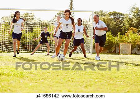 Stock Image - Members Of Female High School Soccer Playing Match. Fotosearch