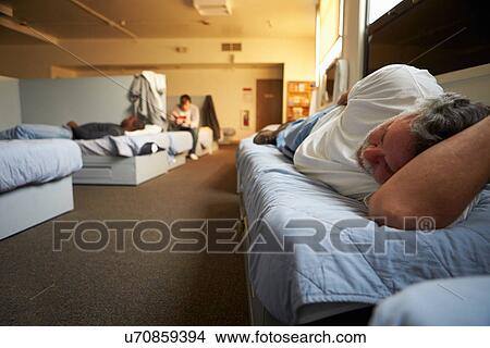 Picture - Men Lying On Beds In Homeless Shelter. Fotosearch