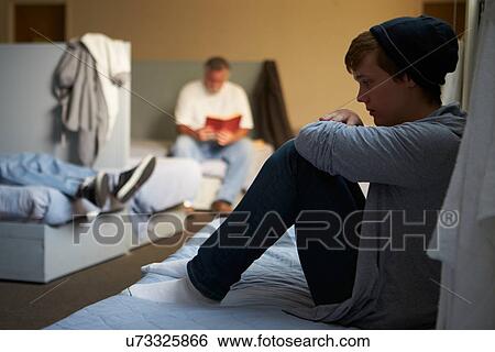 Stock Photograph - Men Lying On Beds In Homeless Shelter. Fotosearch