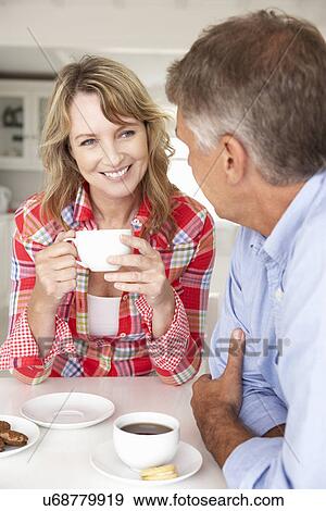 Mid age couple having coffee at home View Large Photo Image Stock Photo - Mid age couple having coffee at home. Fotosearch