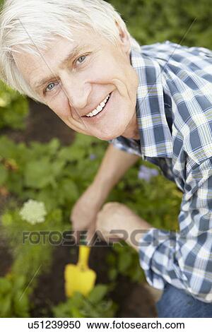 Stock Image - Mid age man gardening. Fotosearch