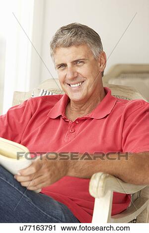 Mid age man reading a book View Large Photo Image Stock Image - Mid age man reading a book. Fotosearch