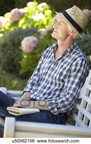 Mid age man reading in garden View Large Photo Image Stock Photograph - Mid age man reading in garden. Fotosearch