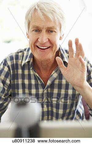 Stock Photo - Mid age man using skype. Fotosearch