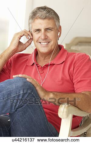 Mid age man wearing earphones View Large Photo Image Stock Photo - Mid age man wearing earphones. Fotosearch