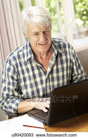 Mid age man working in home office View Large Photo Image Stock Image - Mid age man working in home office. Fotosearch