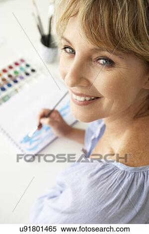 Mid age woman painting with watercolors View Large Photo Image Stock Photography - Mid age woman painting with watercolors. Fotosearch