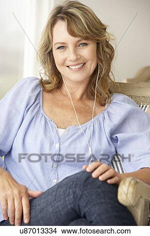 Mid age woman wearing earphones View Large Photo Image Picture - Mid age woman wearing earphones. Fotosearch