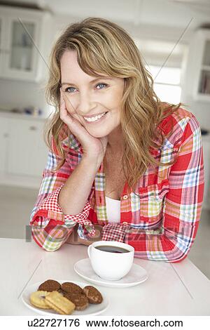 Mid age woman with coffee and biscuits at home View Large Photo Image Stock Photograph - Mid age woman with coffee and biscuits at home. Fotosearch