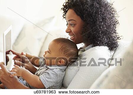 Mother And Baby Playing With Digital Tablet At Home View Large Photo Image Stock Image - Mother And Baby Playing With Digital Tablet At Home. Fotosearch