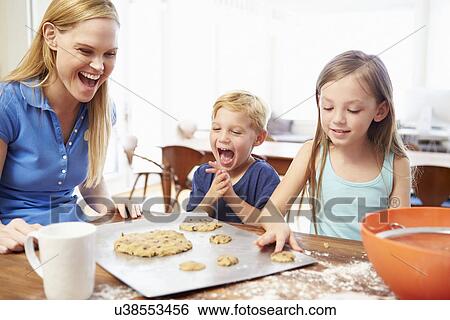 Stock Photograph - Mother And Children Baking Cookies Together At Home. Fotosearch