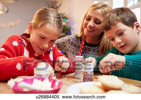 Stock Photography - Mother And Children Decorating Christmas Cookies Together. Fotosearch