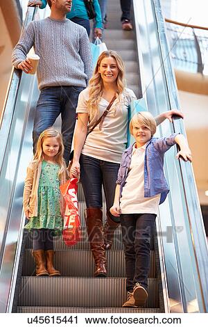 Stock Image - Mother And Children On Escalator In Shopping Mall. Fotosearch