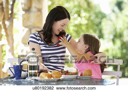 Mother and daughter eating breakfast outdoors View Large Photo Image Stock Image - Mother and daughter eating breakfast outdoors. Fotosearch