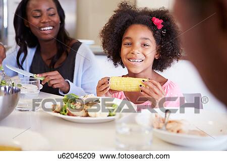 Stock Photo - Mother And Daughter Having Family Meal At Table. Fotosearch